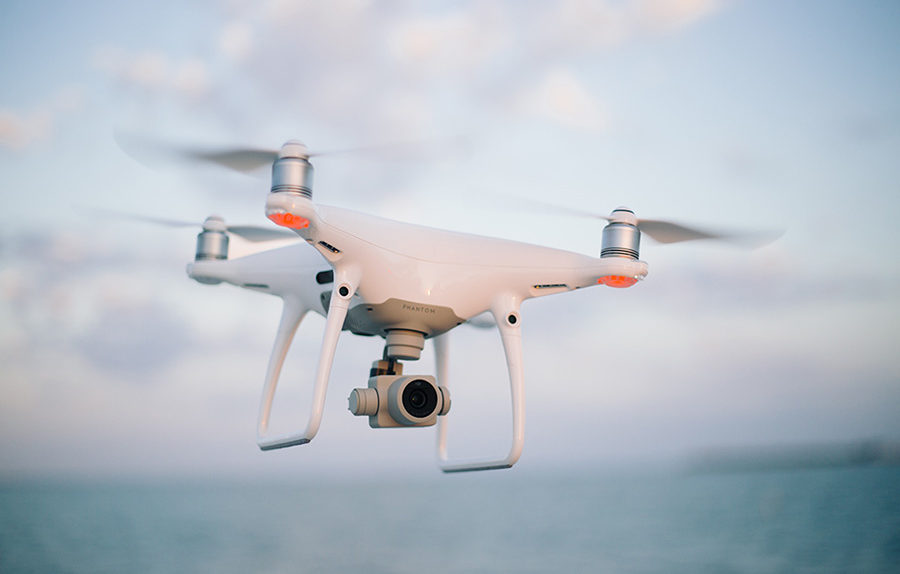 DJI Phantom 4 drone flying near a beach with a blurred background